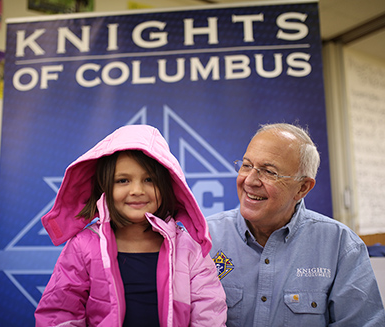 Young child being presented with a new winter coat